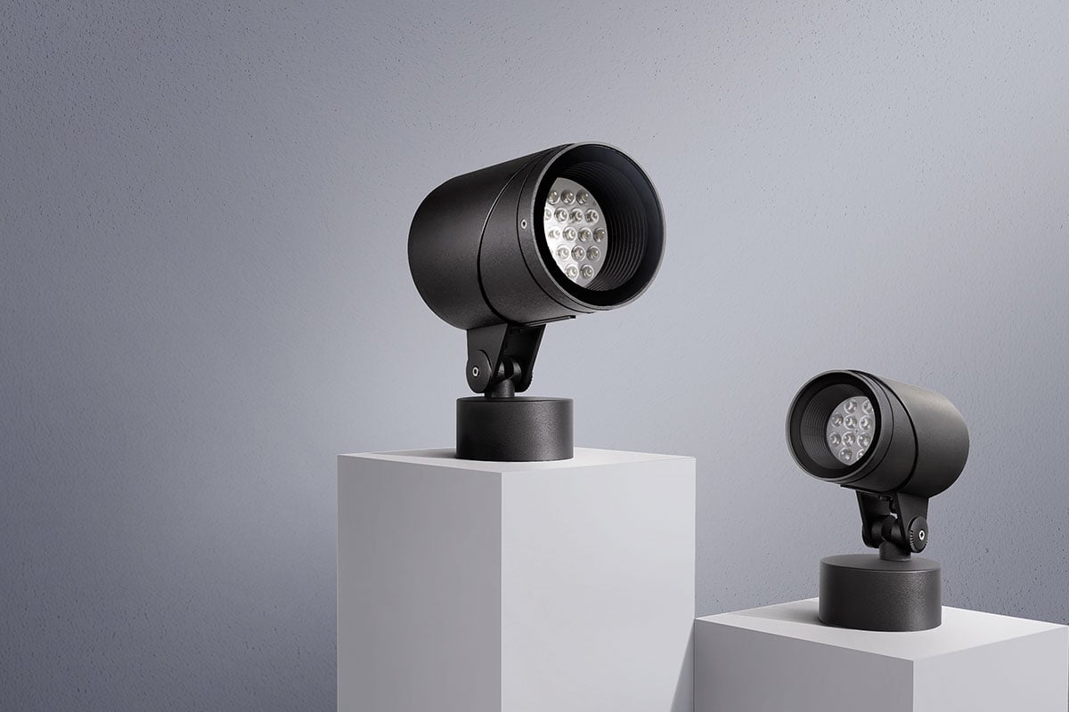 Two compact anthracite-coloured LED outdoor spotlights mounted on pedestals, standing free against a neutral background.