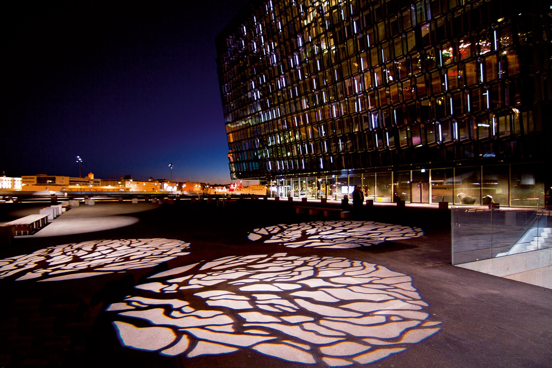 WE-EF FLC240 Gobo Projector casting motif projections onto the forecourt of Harpa Concert Hall Reykjavik – tree crown shadow patterns on the paving at night
