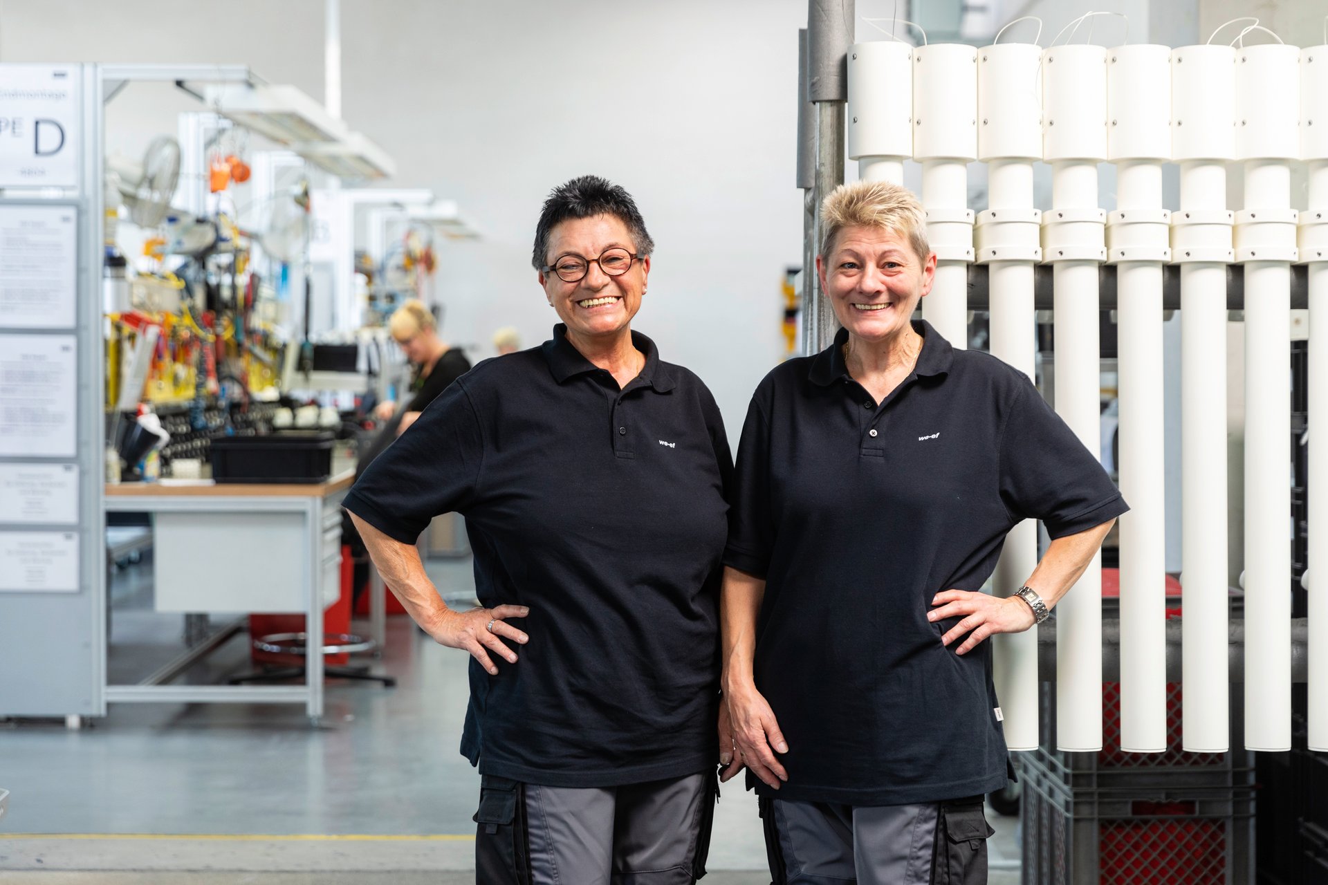 Deux employées de WE-EF sourient et discutent ensemble dans l’usine.