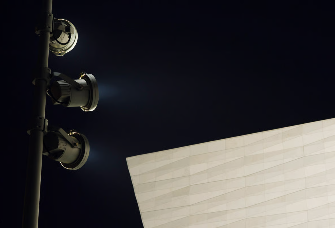 Daytime view of FLC250 projectors on two poles in front of the diamond-textured Jura limestone facade of the National Museum Liverpool