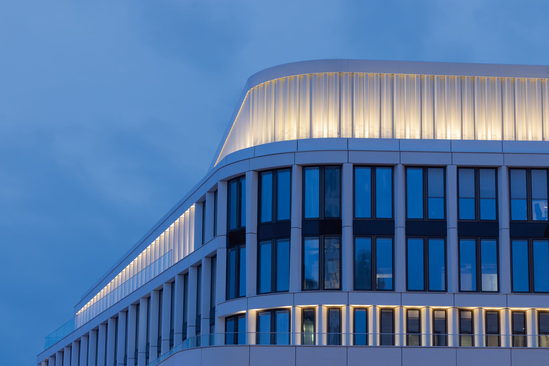 WE-EF FLC121 12W projectors with 3000K warm white LED illuminating lamella cladding roof crown at Zoom commercial building Berlin Kantstrasse