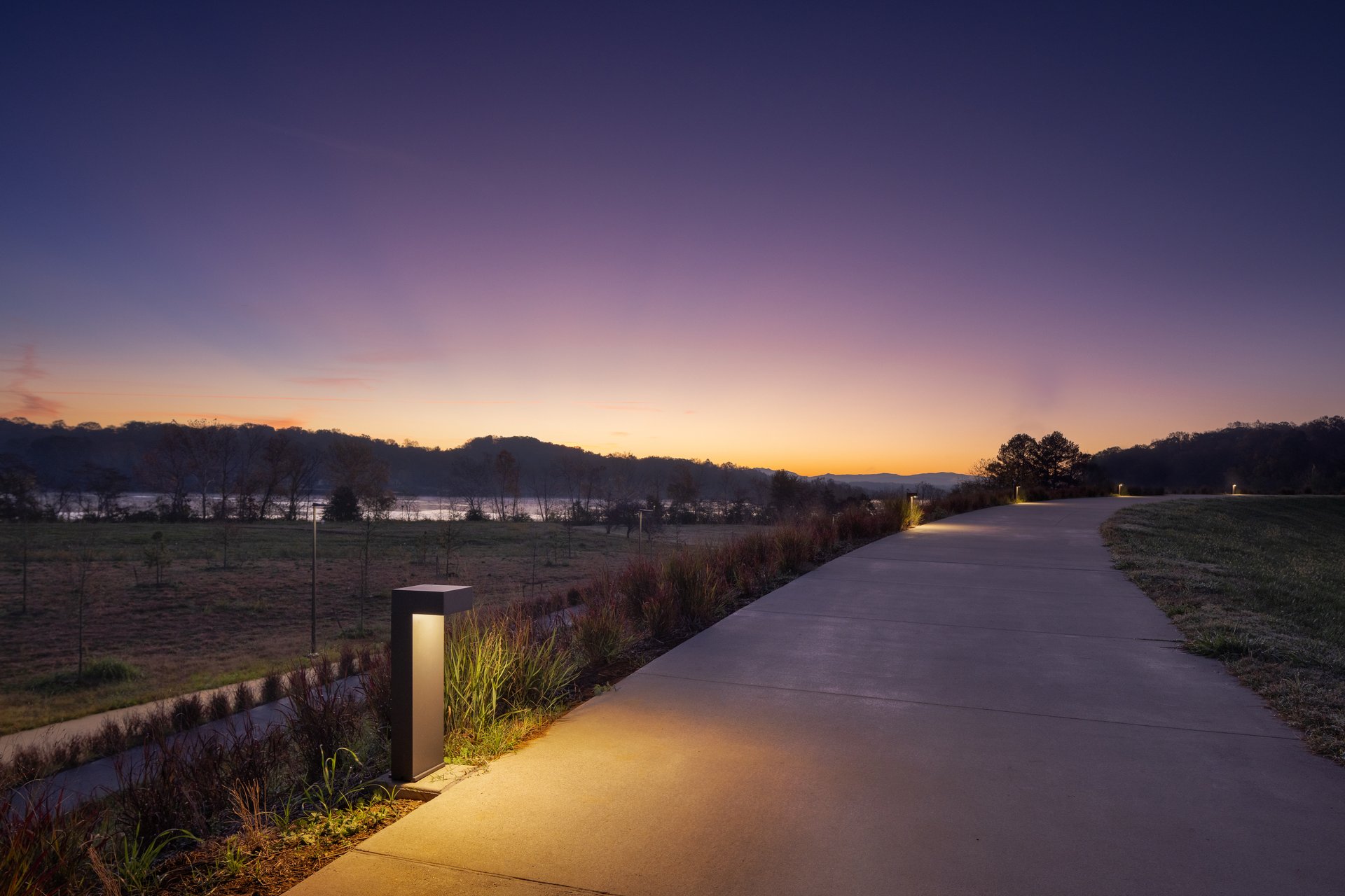 walking path lined by lighted bollards at sunset