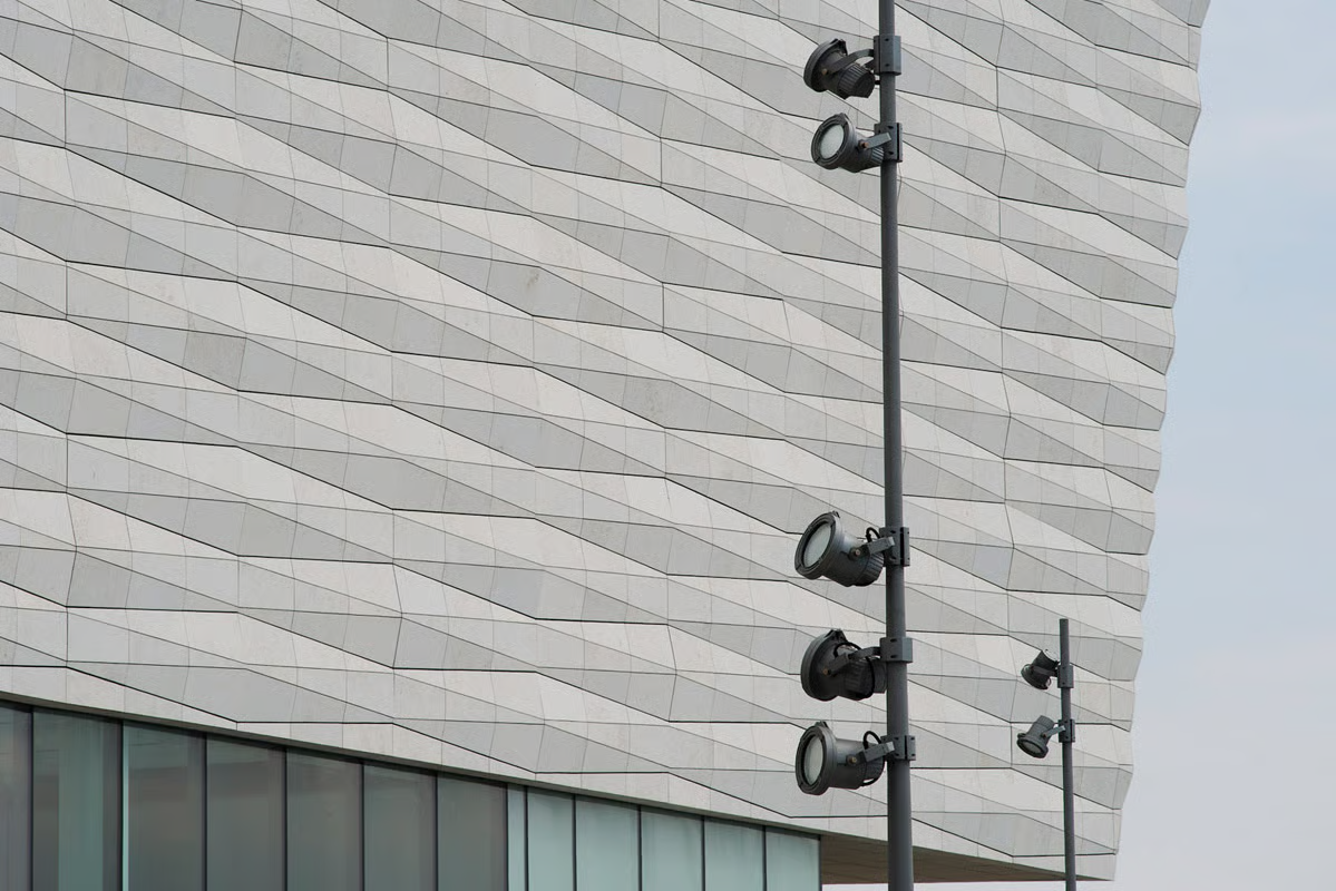 WE-EF wall luminaires mounted on the light stone facade of the National Museum Liverpool, with glass canopy structure and the domed Port of Liverpool Building reflected in the background