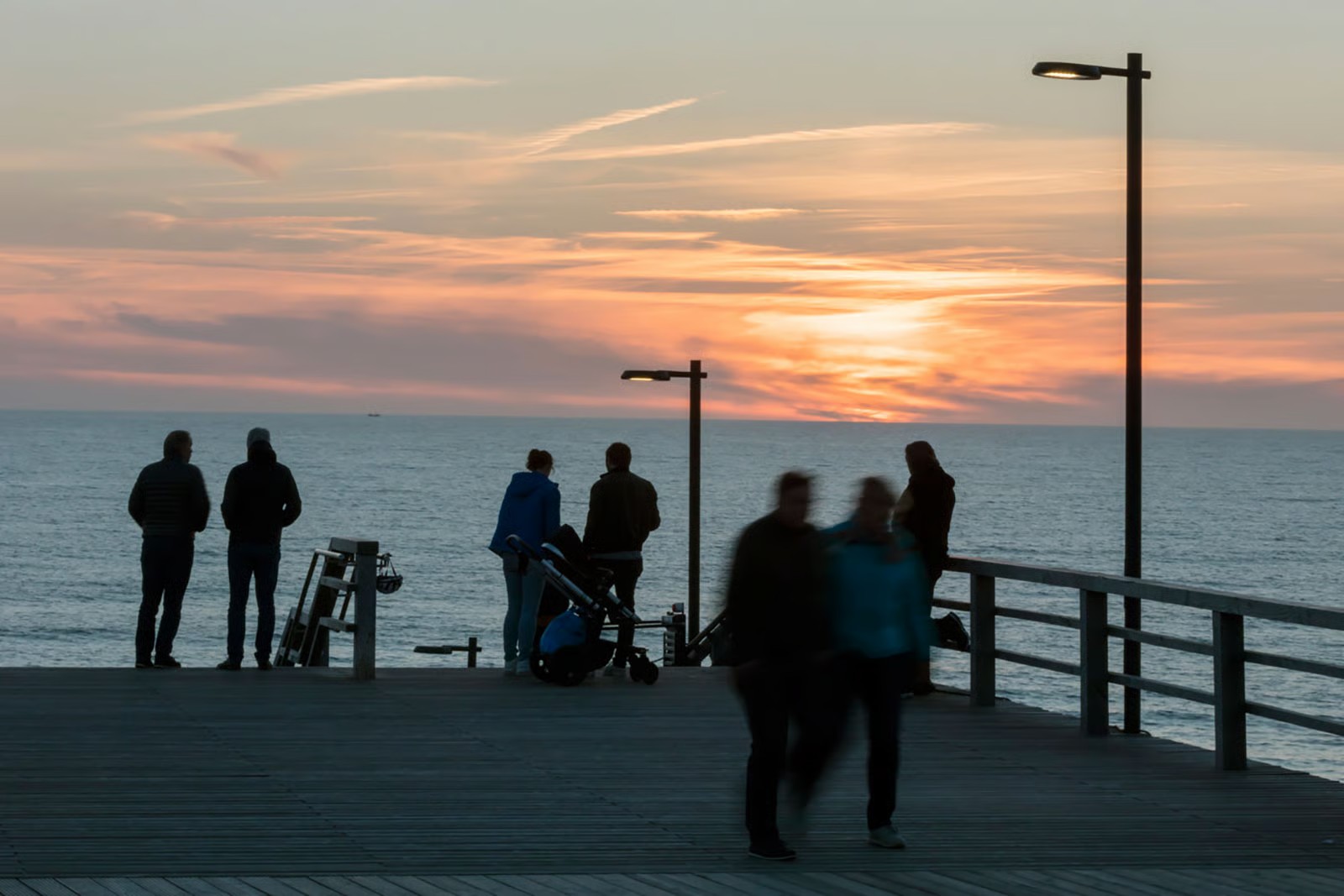 People watching the sunset on the beach stairway viewing platform in Wenningstedt, Sylt, lit by WE-EF pole-mounted luminaires