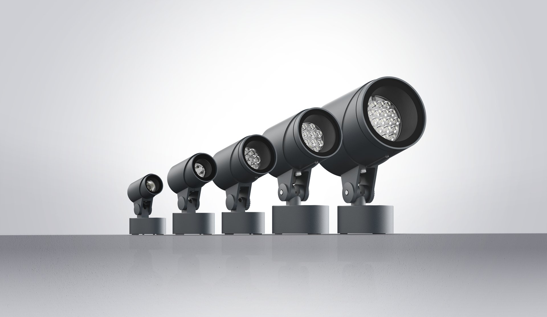 FLC300 series LED outdoor floodlights shown in multiple sizes, featuring a cylindrical design for precise architectural and area lighting.