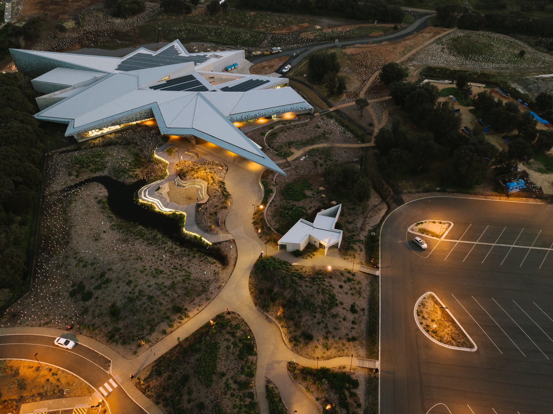 Evening view of the Borneo Cultures Museum in Malaysia with illuminated façade and atmospheric outdoor lighting.