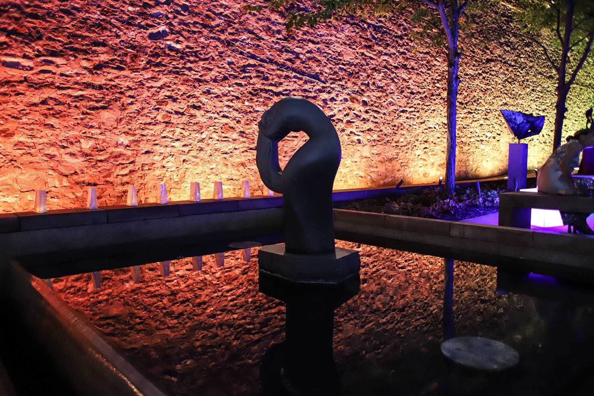 Sculpture garden, the back wall is lit orange